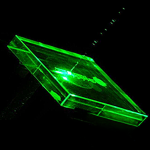 glass glowing green as it is machined by a green DPSS laser for industrial applications